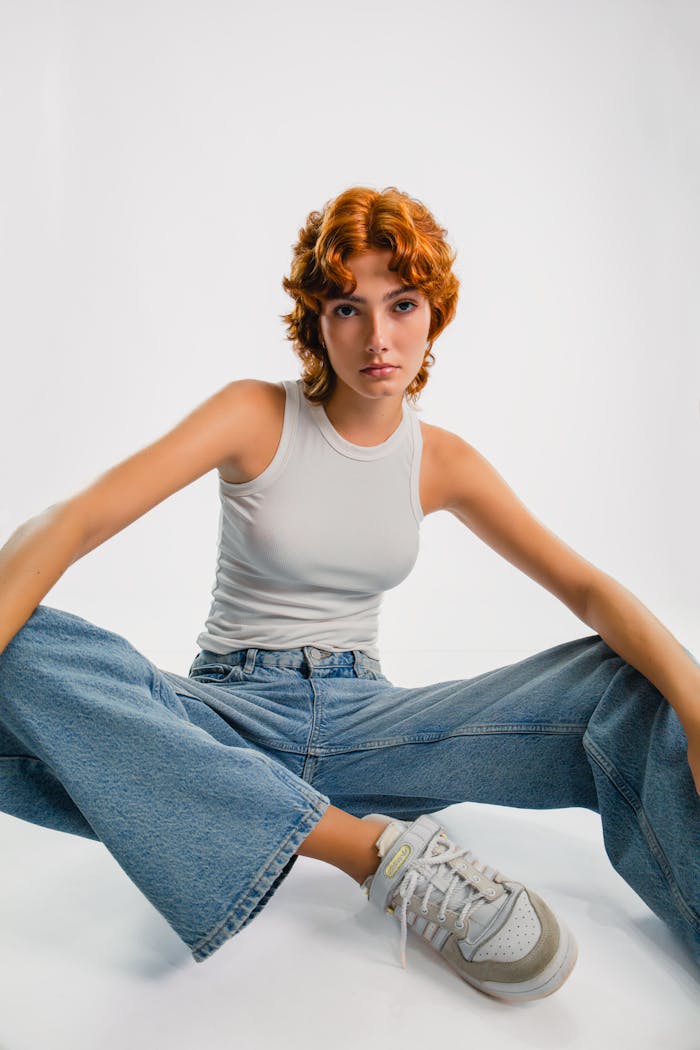 services-10 Young woman in casual attire poses confidently in studio setting.